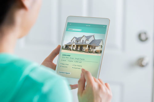 Woman uses tablet to view home listing
