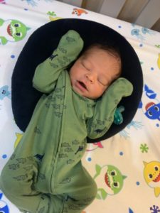 Baby, asleep, wearing green long-sleeved onsie