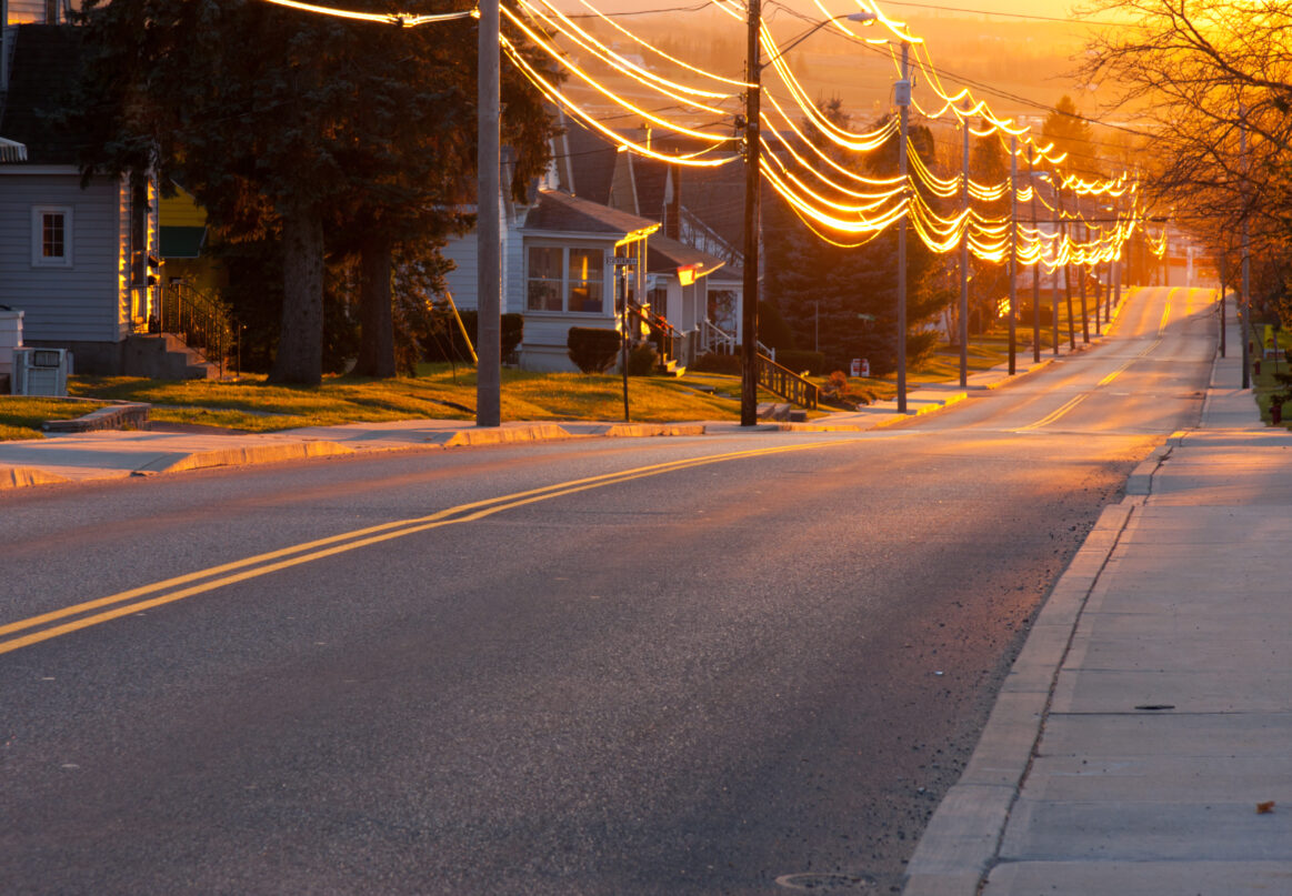 A view down a residential street at sunset.