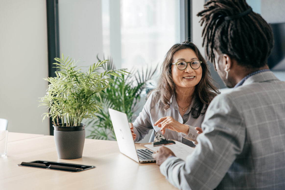 An Asian business woman interviews a Black businessman